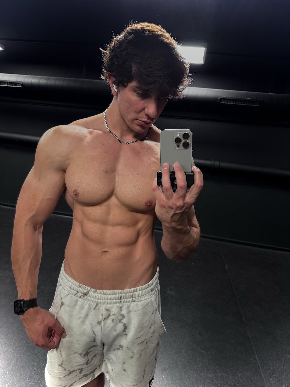 Transformación física masculina en 12 semanas con iluminación de gimnasio de alto contraste.
